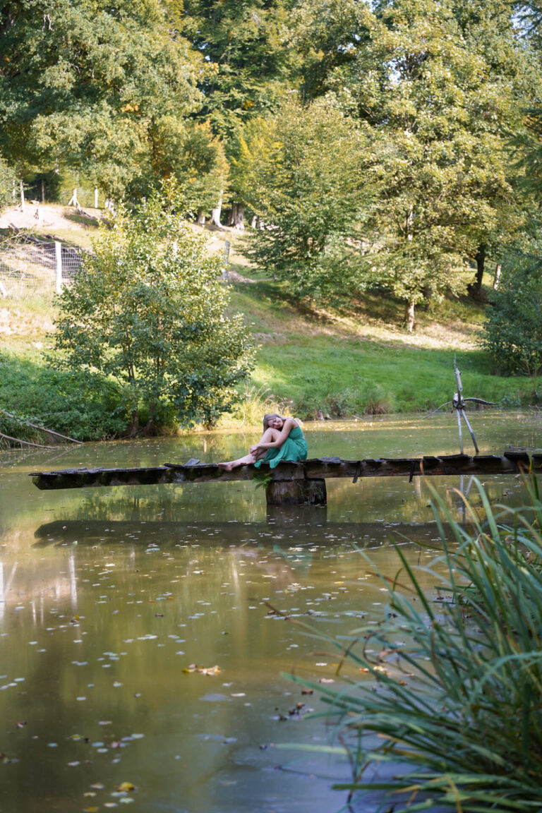 Hypnose in Aschaffenburg - Veronica Albrecht sitzt auf einem Steg am Wasser